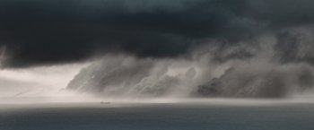 Movie still from “The Burning Sea” (2021), directed by John Andreas Andersen – A large body of water under a cloudy sky; Extreme Wide shot, High angle