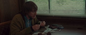 Movie still from “The Cabin in the Woods” (2011), directed by Drew Goddard – A man sitting at a table with papers in front of him; Medium shot, High angle