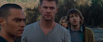 Movie still from “The Cabin in the Woods” (2011), directed by Drew Goddard – A person wearing a gray t - shirt; Close Up shot, Over the shoulder angle