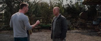 Movie still from “The Cabin in the Woods” (2011), directed by Drew Goddard – A man standing next to another man in a field; Medium shot, Over the shoulder angle