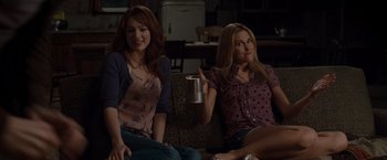 Movie still from “The Cabin in the Woods” (2011), directed by Drew Goddard – Two women sitting on a couch with a cup in their hand; Medium shot, Over the shoulder angle