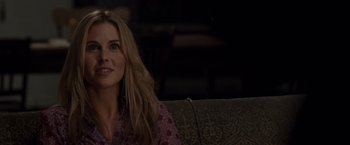 Movie still from “The Cabin in the Woods” (2011), directed by Drew Goddard – A woman sitting on top of a couch in a living room; Close Up shot, Over the shoulder angle