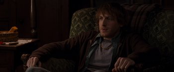 Movie still from “The Cabin in the Woods” (2011), directed by Drew Goddard – A man sitting in a chair looking at the camera; Medium shot, High angle