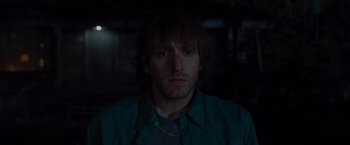 Movie still from “The Cabin in the Woods” (2011), directed by Drew Goddard – A person wearing a green shirt; Close Up shot, Over the shoulder angle