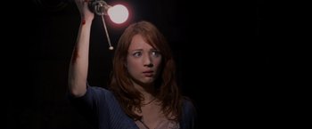 Movie still from “The Cabin in the Woods” (2011), directed by Drew Goddard – A woman standing in the dark under a light; Close Up shot, Low angle