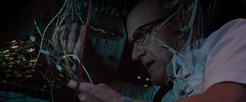 Movie still from “The Cabin in the Woods” (2011), directed by Drew Goddard – An older man wearing glasses looking at wires on a wall; Close Up shot, Low angle