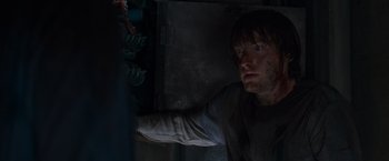 Movie still from “The Cabin in the Woods” (2011), directed by Drew Goddard – A man looking at the camera in a dark room; Close Up shot, Overhead angle