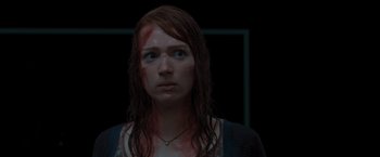 Movie still from “The Cabin in the Woods” (2011), directed by Drew Goddard – A young woman with red hair and a scar on her face; Close Up shot, Over the shoulder angle