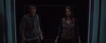 Movie still from “The Cabin in the Woods” (2011), directed by Drew Goddard – A couple of people standing next to each other in the dark; Medium shot, Over the shoulder angle