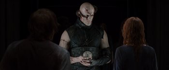 Movie still from “The Cabin in the Woods” (2011), directed by Drew Goddard – A man in a black outfit holding something in his hands; Medium shot, Over the shoulder angle