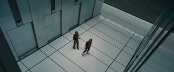 Movie still from “The Cabin in the Woods” (2011), directed by Drew Goddard – Two people standing on a white floor in a room; Wide shot, Overhead angle