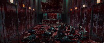 Movie still from “The Cabin in the Woods” (2011), directed by Drew Goddard – A group of people sitting in a room covered in blood; Wide shot, High angle