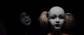 Movie still from “The Cabin in the Woods” (2011), directed by Drew Goddard – A woman wearing a white mask and a black mask; Close Up shot, Low angle