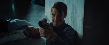 Movie still from “The Cabin in the Woods” (2011), directed by Drew Goddard – A woman is holding a gun in a room; Close Up shot, Low angle