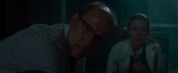 Movie still from “The Cabin in the Woods” (2011), directed by Drew Goddard – An older man wearing glasses and a white shirt; Close Up shot, Over the shoulder angle