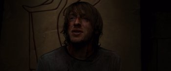 Movie still from “The Cabin in the Woods” (2011), directed by Drew Goddard – A person wearing a black shirt; Close Up shot, High angle