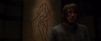 Movie still from “The Cabin in the Woods” (2011), directed by Drew Goddard – A man standing in front of a painting of a naked woman; Medium shot, Over the shoulder angle