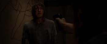 Movie still from “The Cabin in the Woods” (2011), directed by Drew Goddard – A person holding a camera taking a picture of a man with long hair; Medium shot, Over the shoulder angle