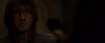 Movie still from “The Cabin in the Woods” (2011), directed by Drew Goddard – A man with long dark hair is sitting in a dark room; Close Up shot, Over the shoulder angle