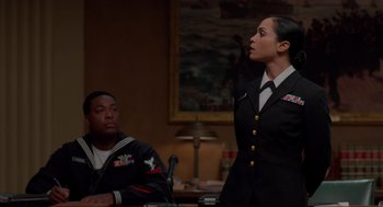 Movie still from “The Caine Mutiny Court-Martial” (2023), directed by William Friedkin – A woman in a military uniform standing in front of a man; Medium shot, Over the shoulder angle