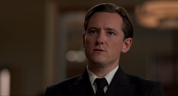 Movie still from “The Caine Mutiny Court-Martial” (2023), directed by William Friedkin – A person wearing a suit and tie; Close Up shot, Over the shoulder angle