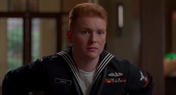 Movie still from “The Caine Mutiny Court-Martial” (2023), directed by William Friedkin – A man with red hair wearing a navy uniform; Close Up shot, Over the shoulder angle