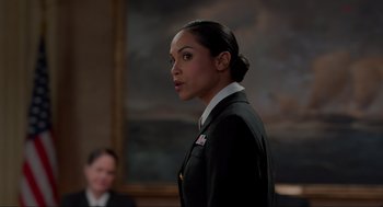 Movie still from “The Caine Mutiny Court-Martial” (2023), directed by William Friedkin – A woman in a uniform standing in front of a painting; Close Up shot, Over the shoulder angle