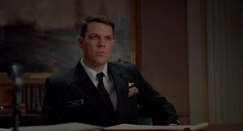 Movie still from “The Caine Mutiny Court-Martial” (2023), directed by William Friedkin – A man in a uniform sitting at a table; Medium shot, Low angle