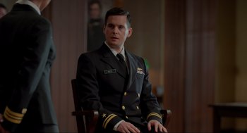 Movie still from “The Caine Mutiny Court-Martial” (2023), directed by William Friedkin – A man in a military uniform sitting in a chair; Medium shot, Over the shoulder angle