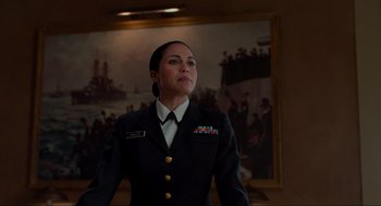 Movie still from “The Caine Mutiny Court-Martial” (2023), directed by William Friedkin – A woman in a uniform standing in front of a painting; Medium shot, Low angle