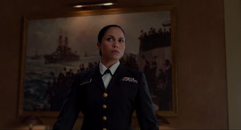 Movie still from “The Caine Mutiny Court-Martial” (2023), directed by William Friedkin – A woman in a uniform standing in front of a painting; Medium shot, Low angle