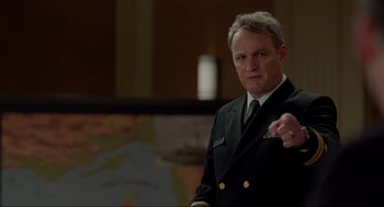 Movie still from “The Caine Mutiny Court-Martial” (2023), directed by William Friedkin – A man in a military uniform pointing to a map; Medium shot, Over the shoulder angle