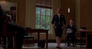 Movie still from “The Caine Mutiny Court-Martial” (2023), directed by William Friedkin – A woman in a military uniform standing in front of a desk; Wide shot, Low angle