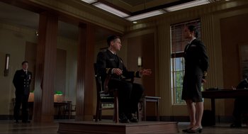 Movie still from “The Caine Mutiny Court-Martial” (2023), directed by William Friedkin – A man and a woman are sitting in a room; Wide shot, Low angle