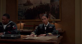 Movie still from “The Caine Mutiny Court-Martial” (2023), directed by William Friedkin – A woman sitting at a table in a military uniform; Medium shot, Over the shoulder angle
