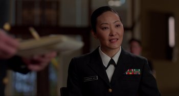 Movie still from “The Caine Mutiny Court-Martial” (2023), directed by William Friedkin – A woman in a uniform is smiling for the camera; Close Up shot, Over the shoulder angle