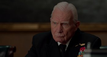 Movie still from “The Caine Mutiny Court-Martial” (2023), directed by William Friedkin – An older man in a suit and tie; Close Up shot, Over the shoulder angle