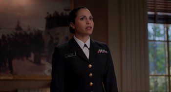 Movie still from “The Caine Mutiny Court-Martial” (2023), directed by William Friedkin – A woman in a military uniform stands in front of a painting; Medium shot, Over the shoulder angle