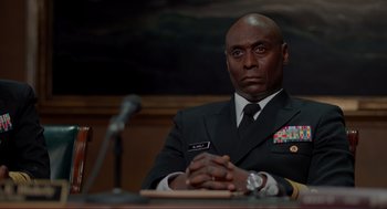 Movie still from “The Caine Mutiny Court-Martial” (2023), directed by William Friedkin – A man sitting in front of microphones in front of a microphone; Close Up shot, Low angle