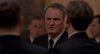 Movie still from “The Caine Mutiny Court-Martial” (2023), directed by William Friedkin – A man in a suit and tie looking at the camera; Close Up shot, Over the shoulder angle