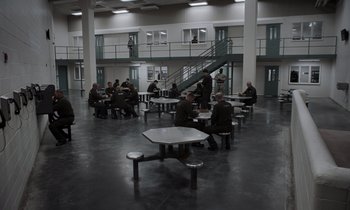 Movie still from “The Card Counter” (2021), directed by Paul Schrader – A group of people sitting at tables in a room; Extreme Wide shot, High angle