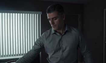 Movie still from “The Card Counter” (2021), directed by Paul Schrader – A man standing in a room looking down at the floor; Medium shot, Low angle