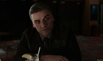 Movie still from “The Card Counter” (2021), directed by Paul Schrader – A man sitting at a table with a glass of lemonade; Close Up shot, Over the shoulder angle
