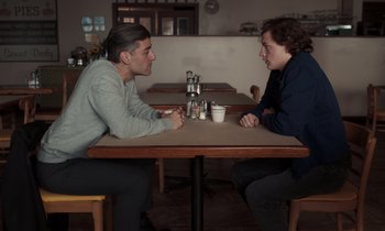 Movie still from “The Card Counter” (2021), directed by Paul Schrader – Two people sitting at a table talking to each other; Medium shot, Over the shoulder angle