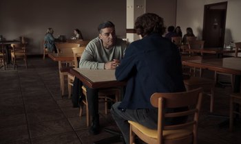Movie still from “The Card Counter” (2021), directed by Paul Schrader – Two people sitting at a table in a restaurant; Medium shot, Over the shoulder angle