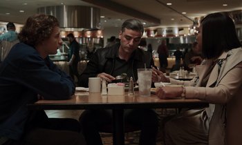 Movie still from “The Card Counter” (2021), directed by Paul Schrader – Three people are sitting at a table in a restaurant; Medium shot, Over the shoulder angle
