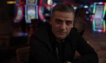 Movie still from “The Card Counter” (2021), directed by Paul Schrader – A person wearing a suit and tie; Close Up shot, Over the shoulder angle