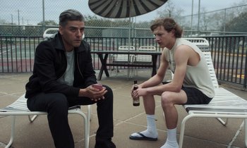 Movie still from “The Card Counter” (2021), directed by Paul Schrader – Two men are sitting on chairs and one is holding a beer; Medium shot, Over the shoulder angle