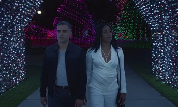 Movie still from “The Card Counter” (2021), directed by Paul Schrader – A man and a woman standing next to each other in front of lights; Medium shot, Low angle