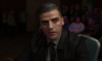 Movie still from “The Card Counter” (2021), directed by Paul Schrader – A person wearing a suit and tie; Close Up shot, Over the shoulder angle